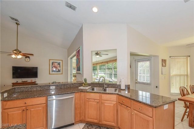 kitchen with dark stone countertops, lofted ceiling, sink, and stainless steel dishwasher