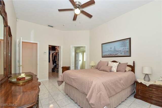 tiled bedroom featuring ensuite bath, a walk in closet, a closet, and ceiling fan