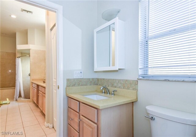 bathroom featuring a shower with curtain, vanity, tile patterned floors, and toilet