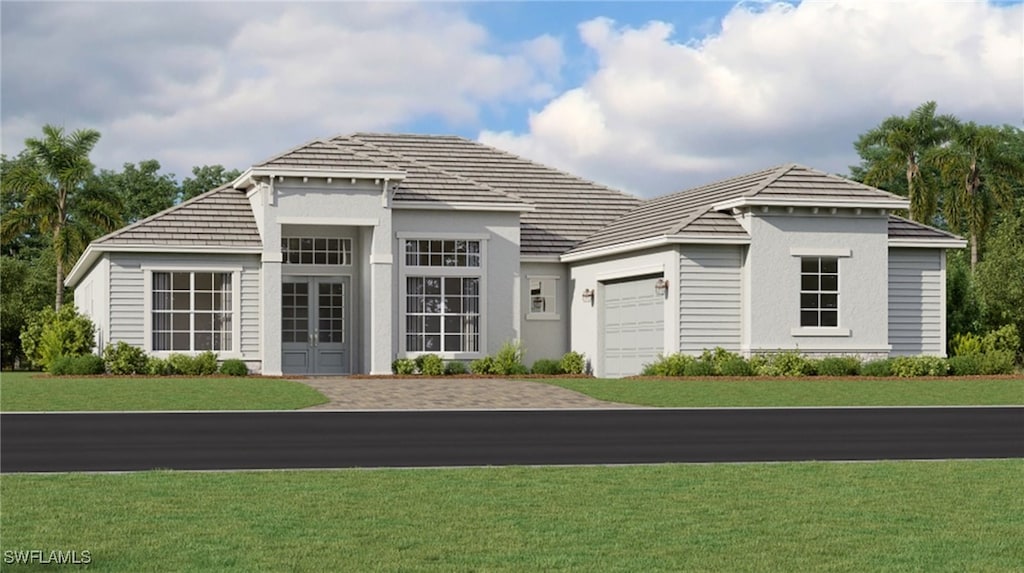 view of front facade with stucco siding, driveway, a front lawn, french doors, and an attached garage