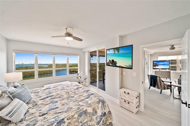 bedroom featuring a textured ceiling, access to outside, light hardwood / wood-style floors, and ceiling fan