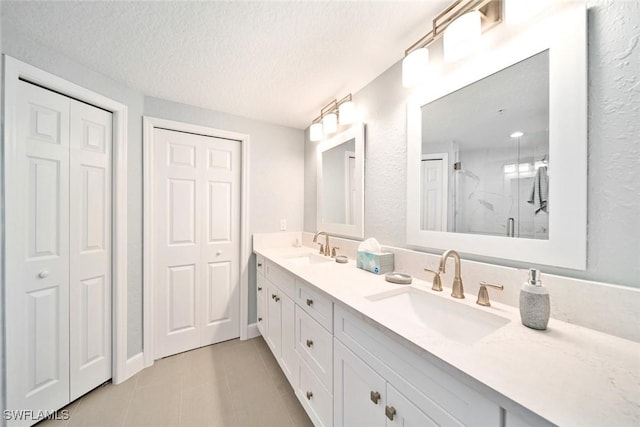 bathroom with vanity, tile patterned floors, a textured ceiling, and walk in shower