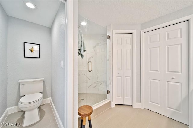 bathroom featuring walk in shower, tile patterned floors, toilet, and a textured ceiling