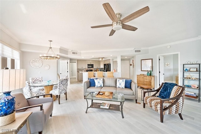 living room featuring ornamental molding, ceiling fan with notable chandelier, and light wood-type flooring