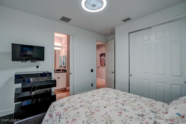 bedroom with a closet, visible vents, connected bathroom, and baseboards