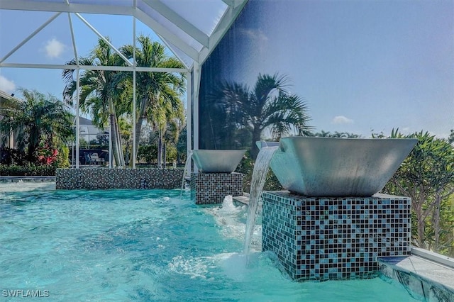 view of swimming pool featuring glass enclosure