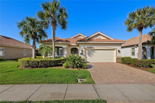 mediterranean / spanish house with a garage and a front lawn