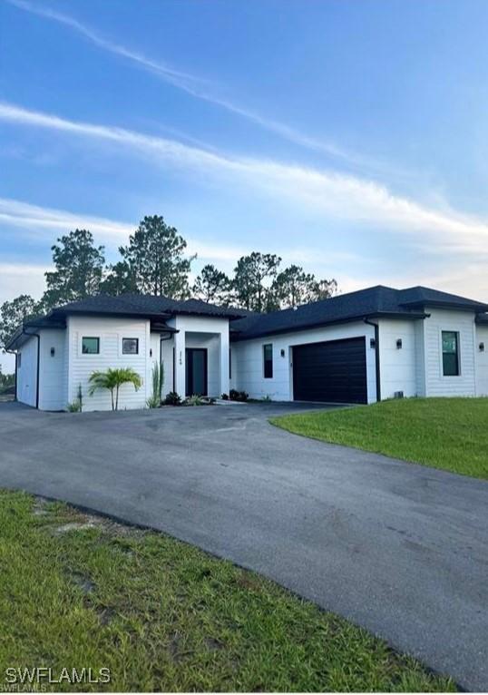 view of front of home with a garage and a front lawn