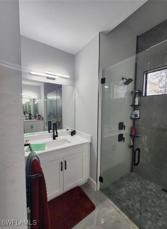 bathroom with vanity and a shower with door