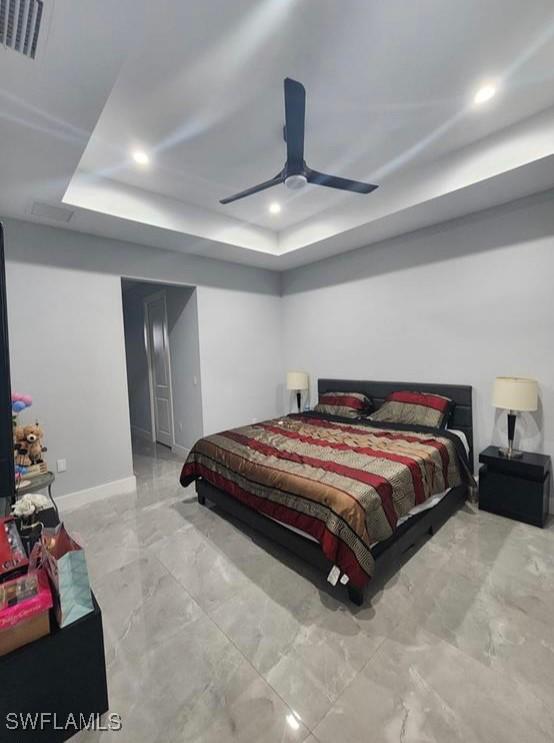 bedroom featuring ceiling fan and a raised ceiling