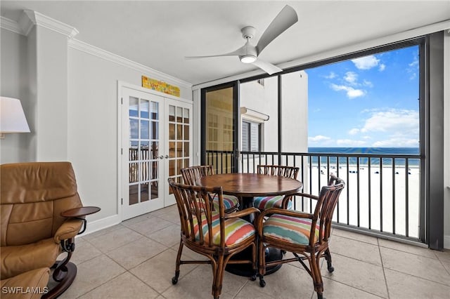 sunroom / solarium with ceiling fan, french doors, a beach view, and a water view