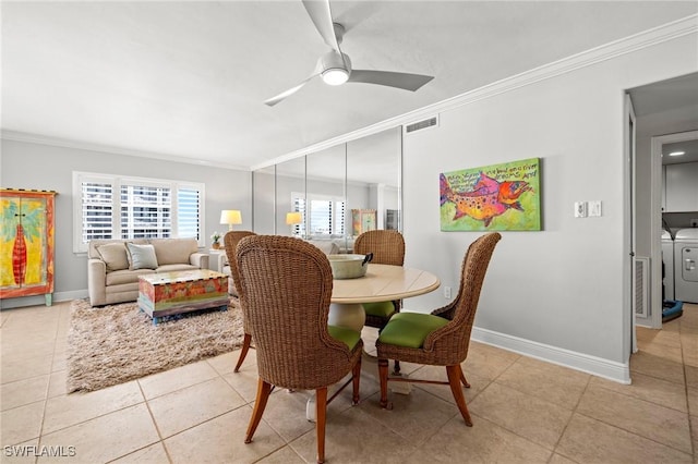 tiled dining space featuring crown molding, washer and clothes dryer, and ceiling fan