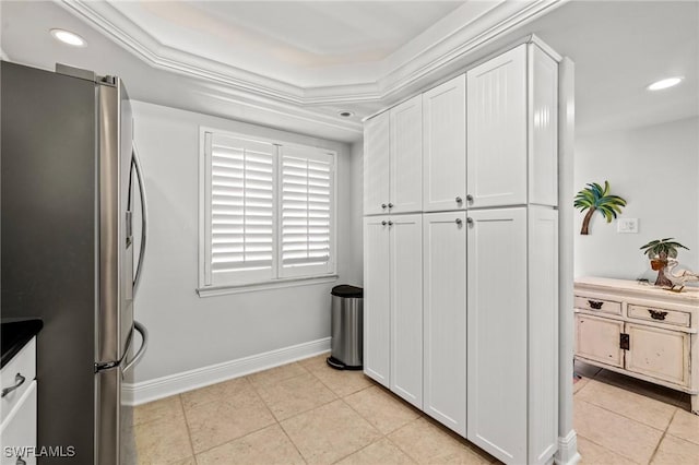 kitchen featuring stainless steel fridge, light tile patterned floors, and white cabinets