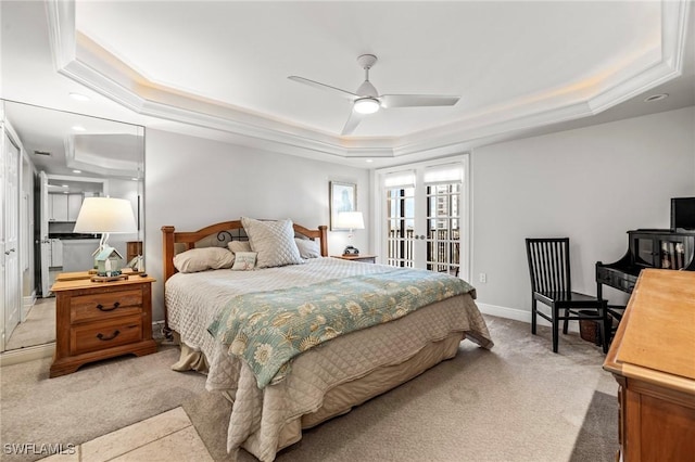 carpeted bedroom featuring access to exterior, a tray ceiling, french doors, and ceiling fan