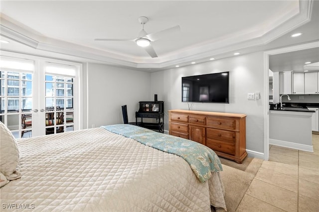 bedroom featuring sink, a tray ceiling, french doors, and ceiling fan