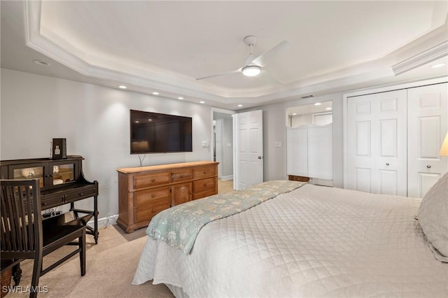 carpeted bedroom featuring ceiling fan and a tray ceiling