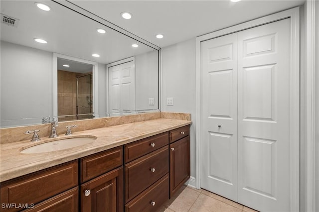 bathroom featuring vanity, tile patterned flooring, and a shower