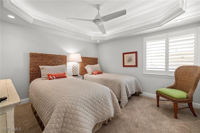 carpeted bedroom featuring a raised ceiling and ceiling fan