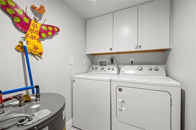 washroom with cabinets, water heater, and washer and dryer