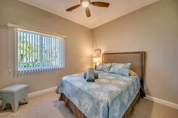 carpeted bedroom with lofted ceiling and ceiling fan