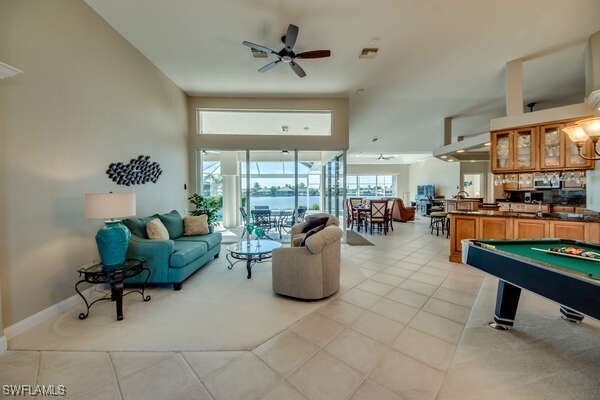 interior space with light tile patterned floors and ceiling fan