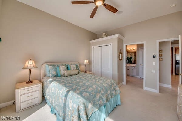 carpeted bedroom with lofted ceiling, stainless steel fridge, ceiling fan, and a closet