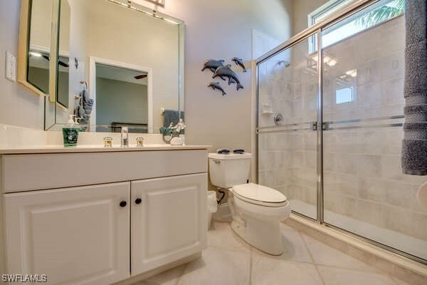 bathroom featuring walk in shower, tile patterned floors, vanity, and toilet