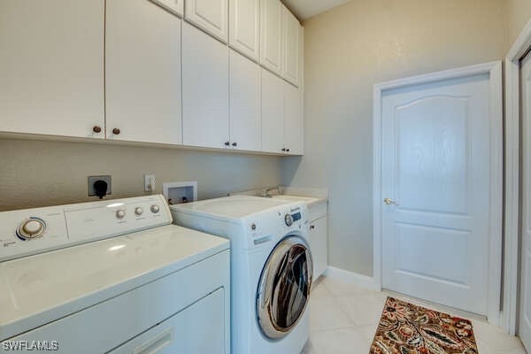 washroom with cabinets, separate washer and dryer, sink, and light tile patterned floors