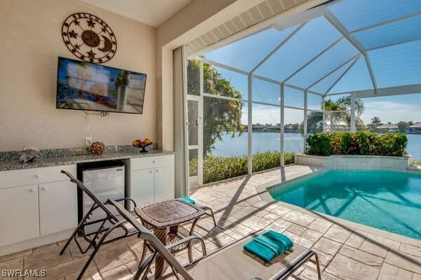 view of pool featuring glass enclosure and a patio area