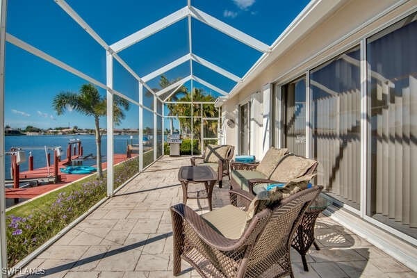 view of patio / terrace with a water view and glass enclosure