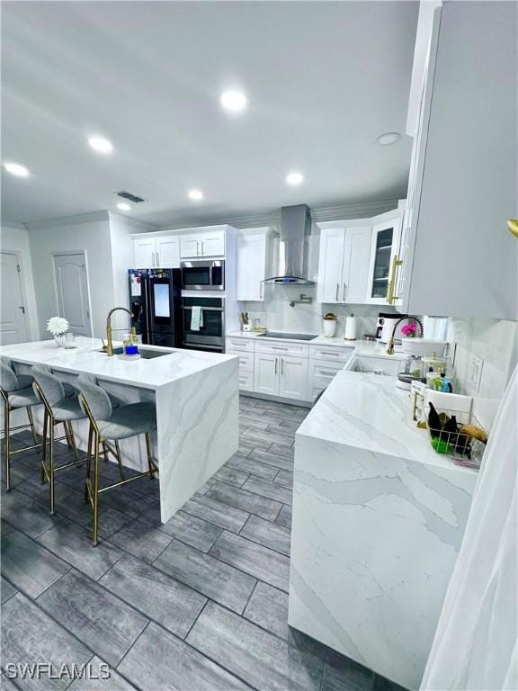 kitchen featuring white cabinetry, wall chimney exhaust hood, sink, and black appliances