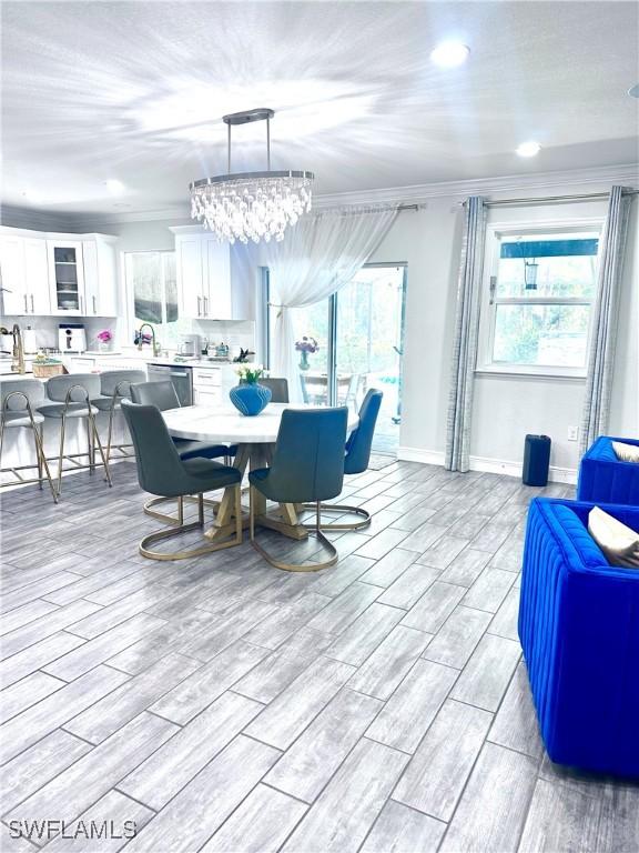 dining room with ornamental molding and light hardwood / wood-style flooring