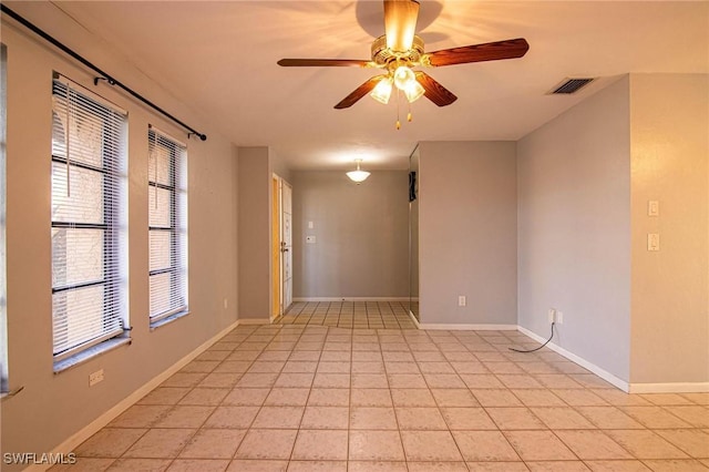 tiled spare room featuring ceiling fan