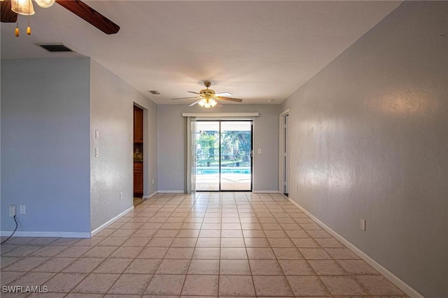 tiled empty room featuring ceiling fan