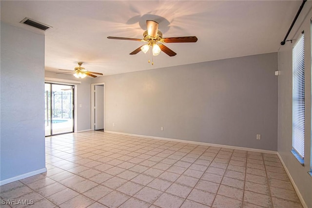 tiled empty room featuring ceiling fan