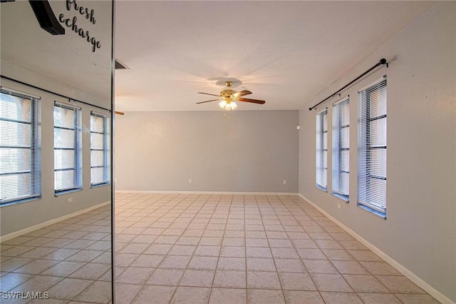 tiled spare room featuring ceiling fan