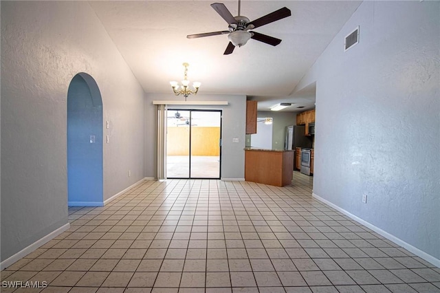 tiled empty room with vaulted ceiling and ceiling fan with notable chandelier