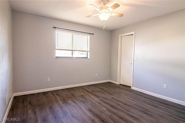 empty room with ceiling fan and dark hardwood / wood-style floors