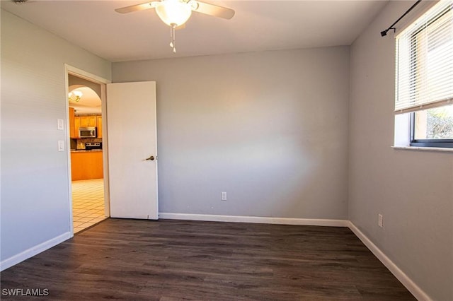 empty room featuring dark wood-type flooring and ceiling fan