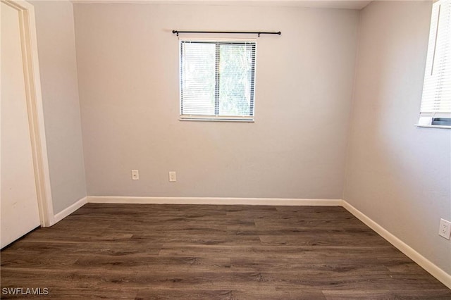 unfurnished room with dark wood-type flooring