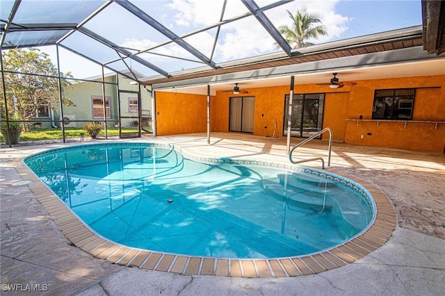 view of pool featuring a patio, ceiling fan, and glass enclosure