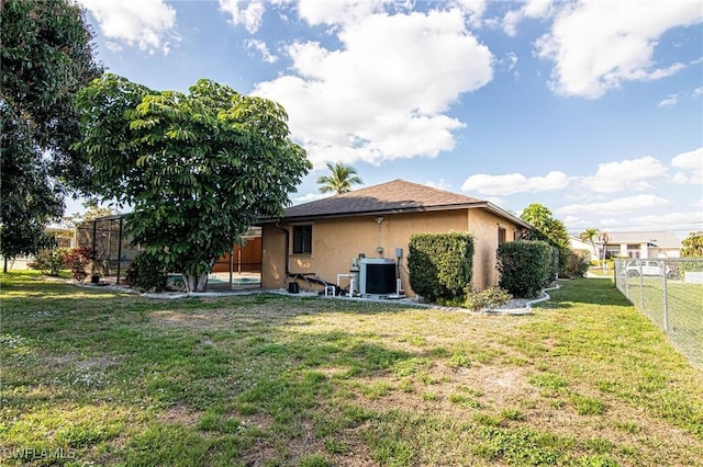 back of house featuring cooling unit and a yard