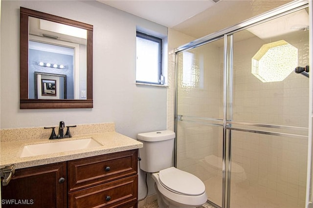 bathroom with vanity, an enclosed shower, and toilet