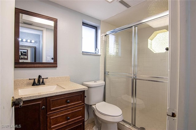 bathroom with vanity, toilet, and a shower with shower door