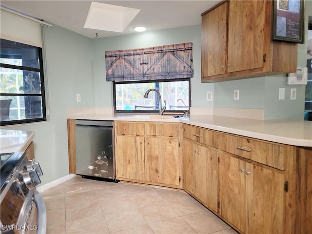 401 SE 8th Ter, Cape Coral, FL 33990 - kitchen featuring appliances with stainless steel finishes, a sink, a skylight, light countertops, and light tile patterned floors