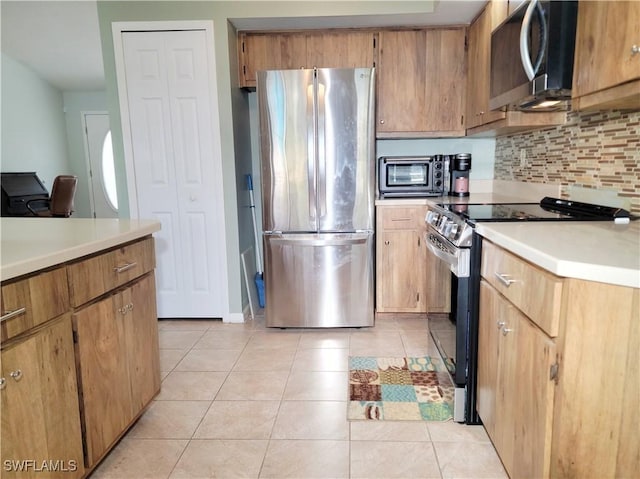 401 SE 8th Ter, Cape Coral, FL 33990 - kitchen with appliances with stainless steel finishes, decorative backsplash, light countertops, and light tile patterned floors