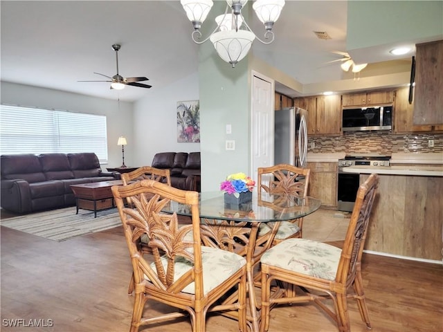 401 SE 8th Ter, Cape Coral, FL 33990 - dining room with a ceiling fan, lofted ceiling, light wood-style flooring, and a chandelier