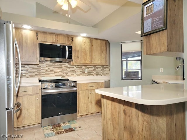 401 SE 8th Ter, Cape Coral, FL 33990 - kitchen featuring appliances with stainless steel finishes, light countertops, backsplash, a peninsula, and vaulted ceiling