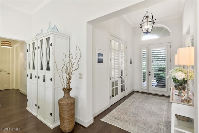 foyer featuring an inviting chandelier, ornamental molding, and dark hardwood / wood-style floors