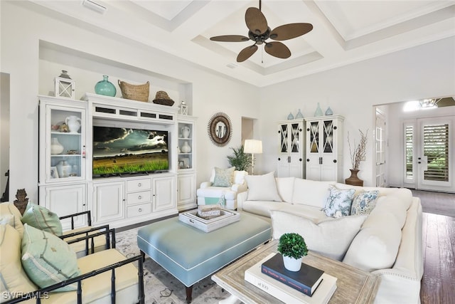 living room featuring wood-type flooring, coffered ceiling, ceiling fan, crown molding, and beam ceiling